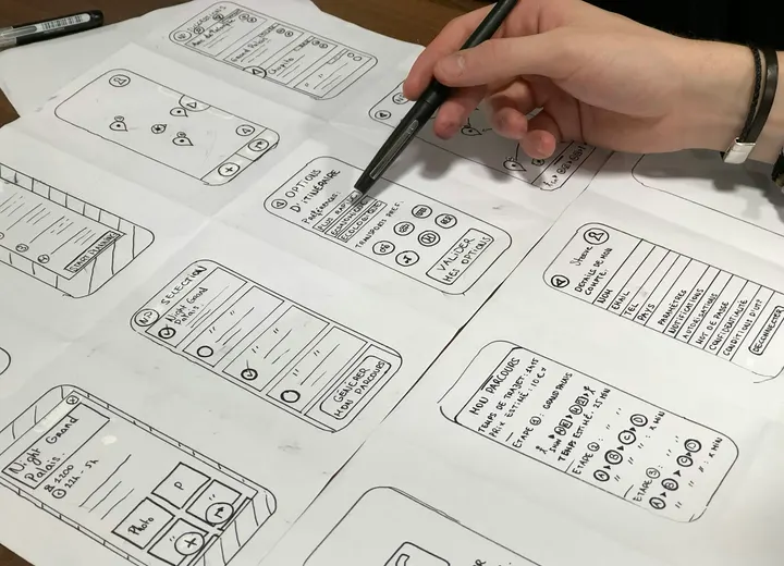 Founder sketching mobile app wireframes on paper while planning a minimum viable product