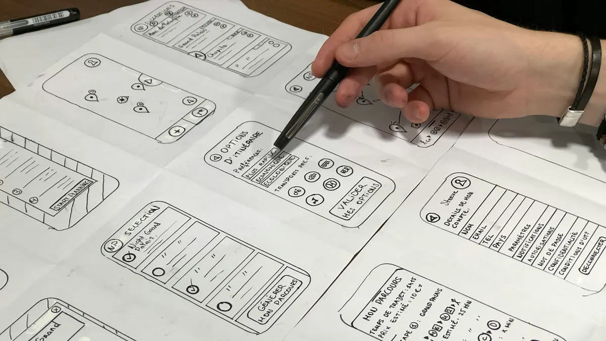 Founder sketching mobile app wireframes on paper while planning a minimum viable product