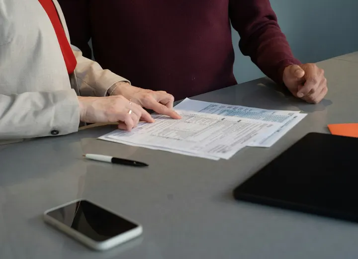 Two founders reviewing business registration documents at a table before choosing a legal structure