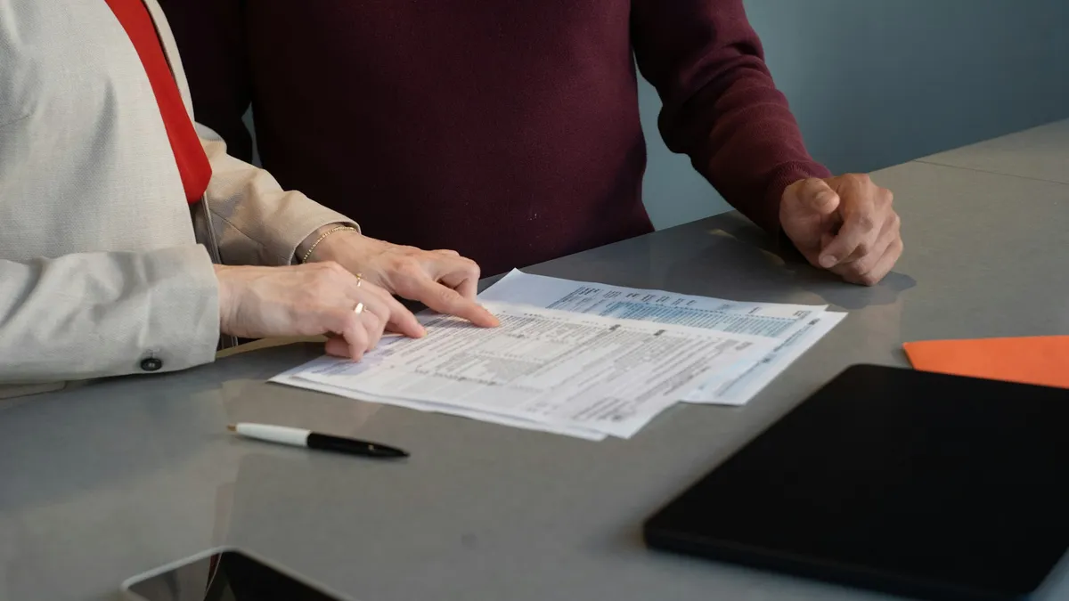 Two founders reviewing business registration documents at a table before choosing a legal structure