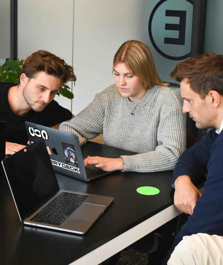 Startup founders collaborating around a laptop, representing the EntrepreneursBreak.com community